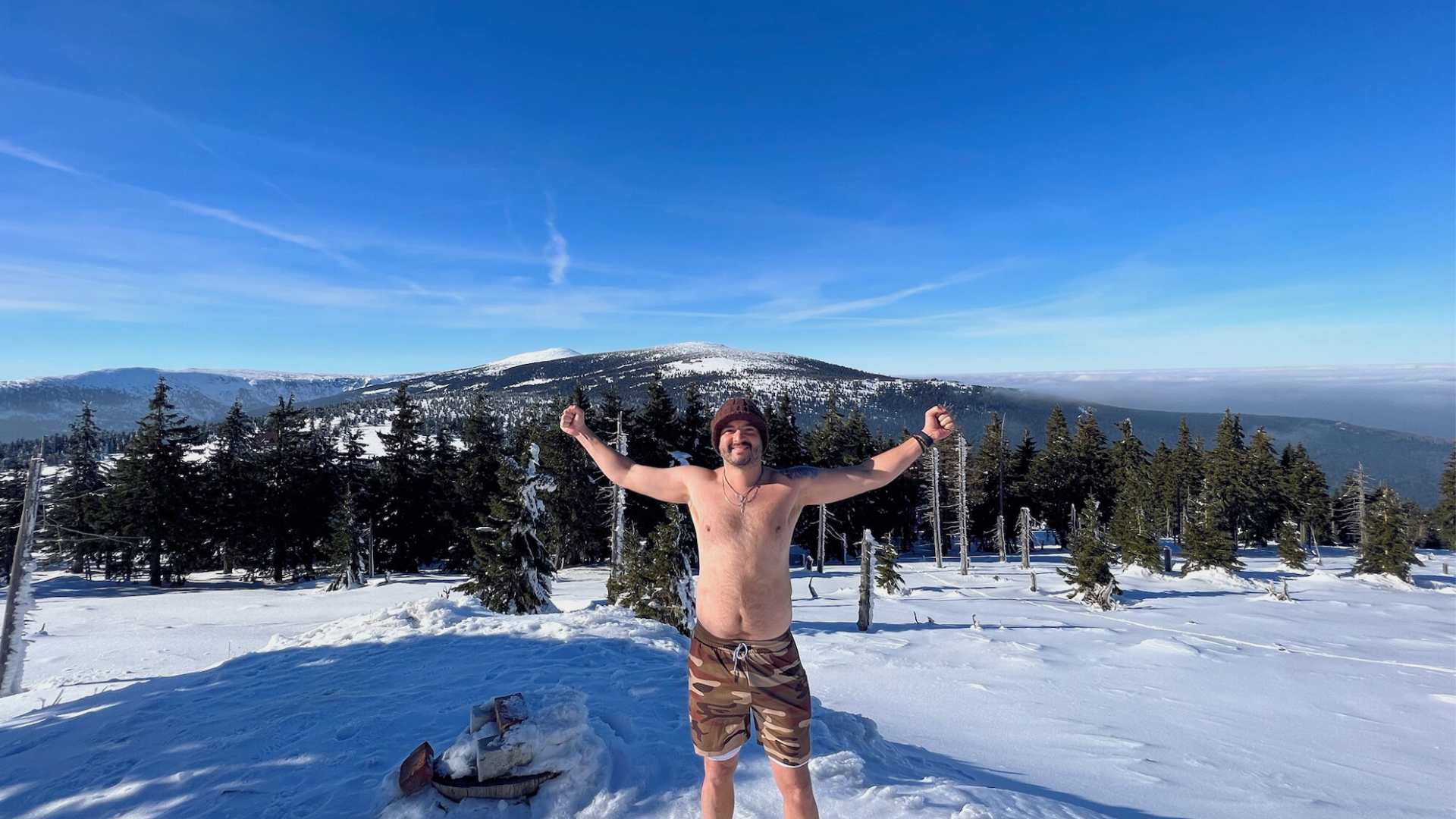 Richi Castro practicando el método Wim Hof en la nieve, con los brazos levantados en señal de fuerza, energía y conexión con la naturaleza.